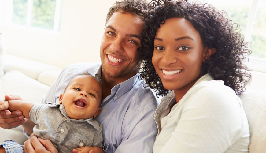 Couple with baby smiling at at Chelsea Dexter Dental Group in Chelsea & Dexter, MI